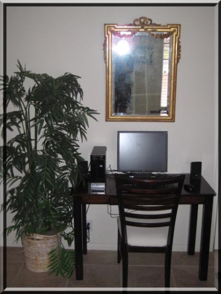 desktop computer on wood desk with gold designer mirror above