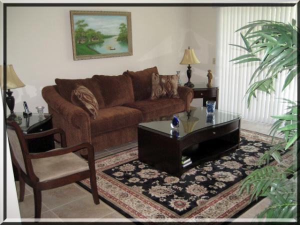 curved glass coffee table and rust colored sofa and accessories